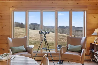 a room with a large window with a camera and chairs at Entire Chalet in Windham NY in Maplecrest