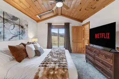 a bedroom with a bed with a television on a dresser at Entire Chalet in Windham NY in Maplecrest