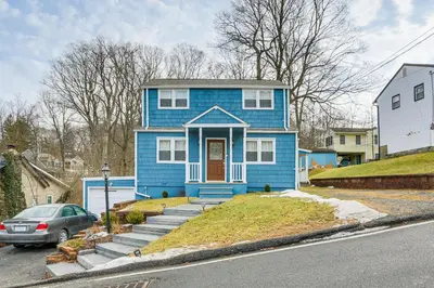 a blue house with a car parked in front of it at Walk to Lake Hopatcong Vibrant Home with Deck! in Hopatcong