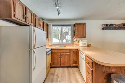 a kitchen with wooden cabinets and a white refrigerator at 3 Mi to Windham Mountain Pet-Friendly Apt with Yard in Hensonville