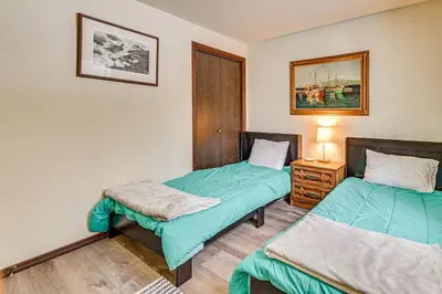 a room with two beds and a table with a lamp at 3 Mi to Windham Mountain Pet-Friendly Apt with Yard in Hensonville
