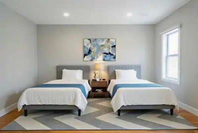 a bedroom with two beds and a painting on the wall at 4BR5BA Luxury World Cup hub in North Bergen