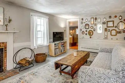 a living room with a couch and a fireplace at Historic 1820s Homestead on Battenkill River! in Arlington