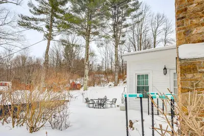 a white house with a table in the snow at Historic 1820s Homestead on Battenkill River! in Arlington