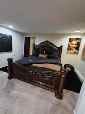 a bedroom with a large wooden bed in a room at cozy 5bd single -family home in Longmeadow in Longmeadow