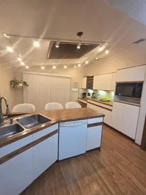 a large kitchen with white cabinets and a sink at cozy 5bd single -family home in Longmeadow in Longmeadow