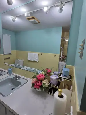a bathroom with a sink and a vase of flowers at cozy 5bd single -family home in Longmeadow in Longmeadow