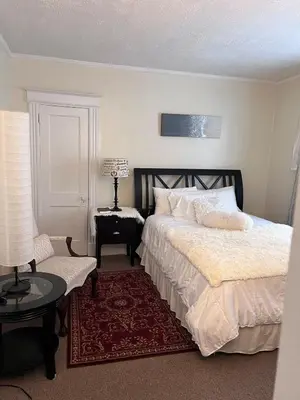 a bedroom with a bed and a table and a lamp at Eden's Cozy Oasis in Windsor
