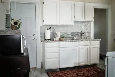 a white kitchen with a sink and a microwave at Eden's Cozy Oasis in Windsor