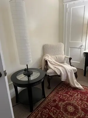 a room with a table and a chair and a lamp at Eden's Cozy Oasis in Windsor