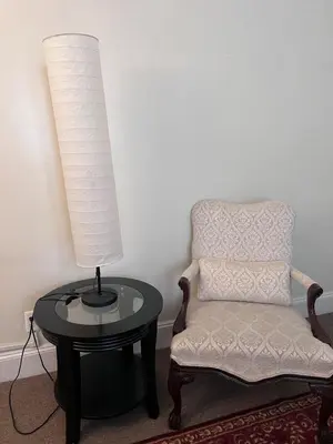 a room with a chair and a table and a lamp at Eden's Cozy Oasis in Windsor