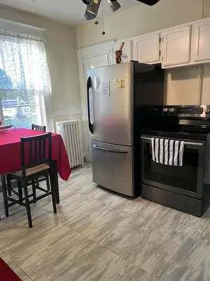 a kitchen with a stainless steel refrigerator and a table at Eden's Cozy Oasis in Windsor