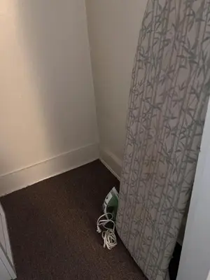 a corner of a room with a curtain on the floor at Eden's Cozy Oasis in Windsor