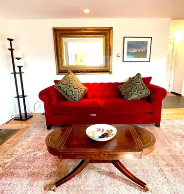 a red couch in a living room with a table at Cozy 3BR Home - Hudson Valley views near Woodbury Commons in Highland Mills