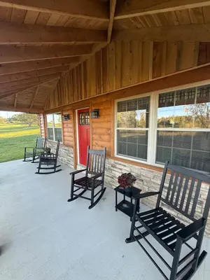 four rocking chairs sitting on a porch of a house at Cattail Cabin in Waterville