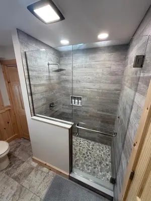 a bathroom with a shower with a glass door at Cattail Cabin in Waterville