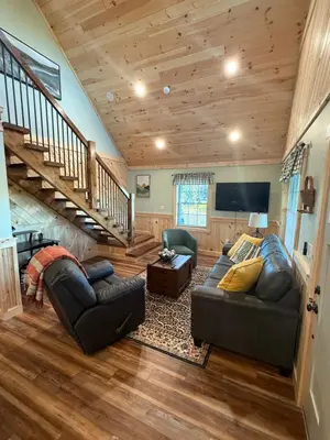 a living room with two couches and a tv at Cattail Cabin in Waterville
