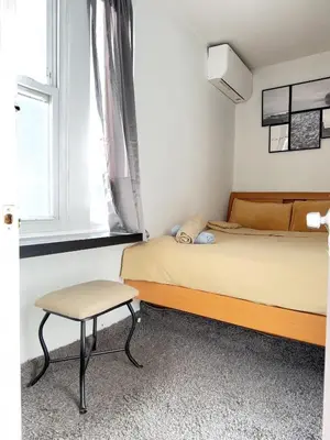 a bedroom with a bed and a chair and a window at \u7ebd\u7ea6\u53d1\u62c9\u76db\u5e72\u51c0\u6574\u6d01\u5b89\u5168\u5c0f\u5355\u95f4 in Flushing