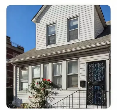 a white house with a porch with a door and flowers at \u7ebd\u7ea6\u53d1\u62c9\u76db\u5e72\u51c0\u6574\u6d01\u5b89\u5168\u5c0f\u5355\u95f4 in Flushing