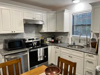 a kitchen with white cabinets and a black stove top oven at Woodside Haven - Game Room - Central AC - Pet Friendly in Tobyhanna