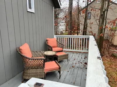 a porch with two chairs and a table on a house at Woodside Haven - Game Room - Central AC - Pet Friendly in Tobyhanna