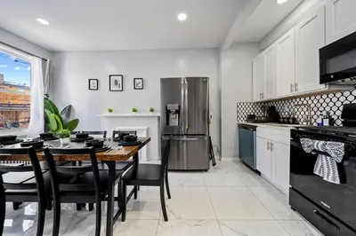 a kitchen with a table and a refrigerator at 3BR duplex near MetLife! w/ Parking! mins to NY in Jersey City