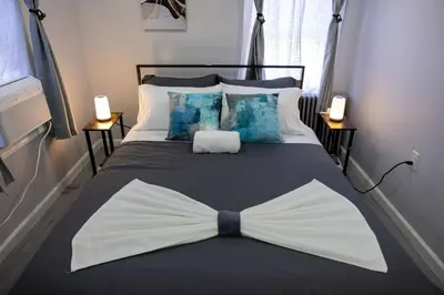 a bedroom with a bed with a bow tie on it at 3BR duplex near MetLife! w/ Parking! mins to NY in Jersey City