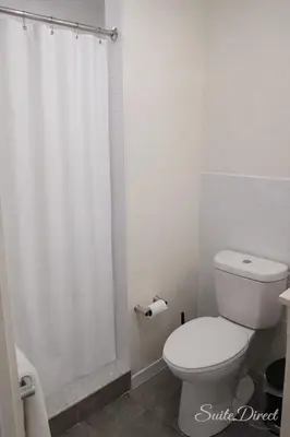 a white bathroom with a toilet and a shower at Pratt St Brand New Studio Loft Elevator Building in Hartford