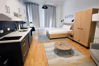 a small kitchen and living room with a bed and a table at Pratt St Brand New Studio Loft Elevator Building in Hartford