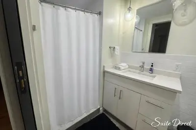 a bathroom with a white shower curtain and a sink at Pratt St Brand New Studio Loft Elevator Building in Hartford