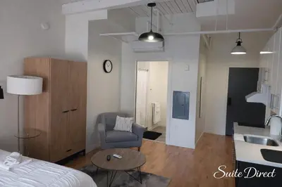 a living room with a bed and a couch and a table at Pratt St Brand New Studio Loft Elevator Building in Hartford