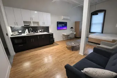 a kitchen and living room with a couch and a bed at Pratt St Brand New Studio Loft Elevator Building in Hartford