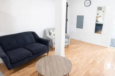 a living room with a blue couch and a table at Pratt St Brand New Studio Loft Elevator Building in Hartford