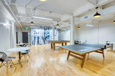 a room with two ping pong tables and chairs at Pratt St Brand New Studio Loft Elevator Building in Hartford