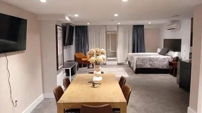 a living room with a room with a bed and a table at Rose Hotel Near Yankee Stadium in Bronx