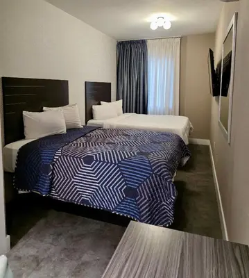 a hotel room with two beds in it at Rose Hotel Near Yankee Stadium in Bronx