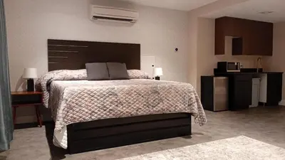 a bedroom with a large bed and a kitchen at Rose Hotel Near Yankee Stadium in Bronx