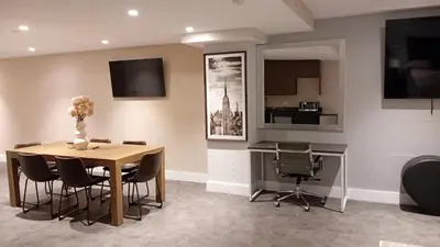a dining room with a table and chairs and a desk at Rose Hotel Near Yankee Stadium in Bronx