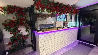 a restaurant with red flowers on the wall at Rose Hotel Near Yankee Stadium in Bronx