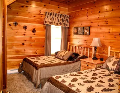 a bedroom with two beds in a log cabin at Wildberry Chalet in Stamford