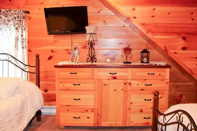 a bedroom with a dresser with a tv on the wall at Wildberry Chalet in Stamford