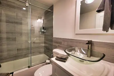 a bathroom with a sink and a toilet and a mirror at Curated Suite with Soaking Tub and Walk to Whole Foods in Jericho