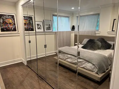 a bedroom with a bed and a glass wall at Curated Suite with Soaking Tub and Walk to Whole Foods in Jericho