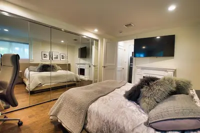 a bedroom with two beds and a mirror at Curated Suite with Soaking Tub and Walk to Whole Foods in Jericho