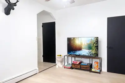 a living room with a flat screen tv on a tv stand at 3BR home in Jersey city ! near metlife & NYC train in Jersey City