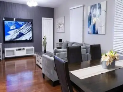 a living room with a dining table and a television at Elegant 3BR Stay | Mins to NYC • Near Dream Mall in Newark