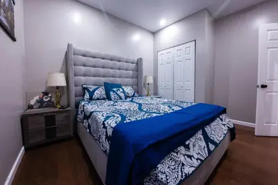 a bedroom with a large bed with a blue comforter at Elegant 3BR Stay | Mins to NYC • Near Dream Mall in Newark