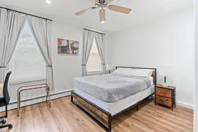 a bedroom with a bed and a ceiling fan at Cozy Retreat 15Min to NYC, FIFA, Mall,FREE Parking - Apartment in North Bergen