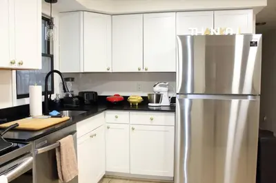 a kitchen with white cabinets and a stainless steel refrigerator at Spacious New4BR 3BA 2kit GameRm Firepit Amenity in Tobyhanna