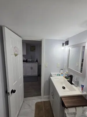 a white bathroom with a sink and a kitchen at Private Executive Suite in Waterbury